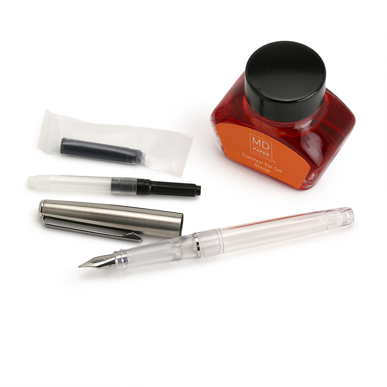 components of the Limited Edition Fountain Pen set from Midori, foubtain pen, metal cap, converter,  ink cartridge and a 30ml bottle of orange fountain pen ink 