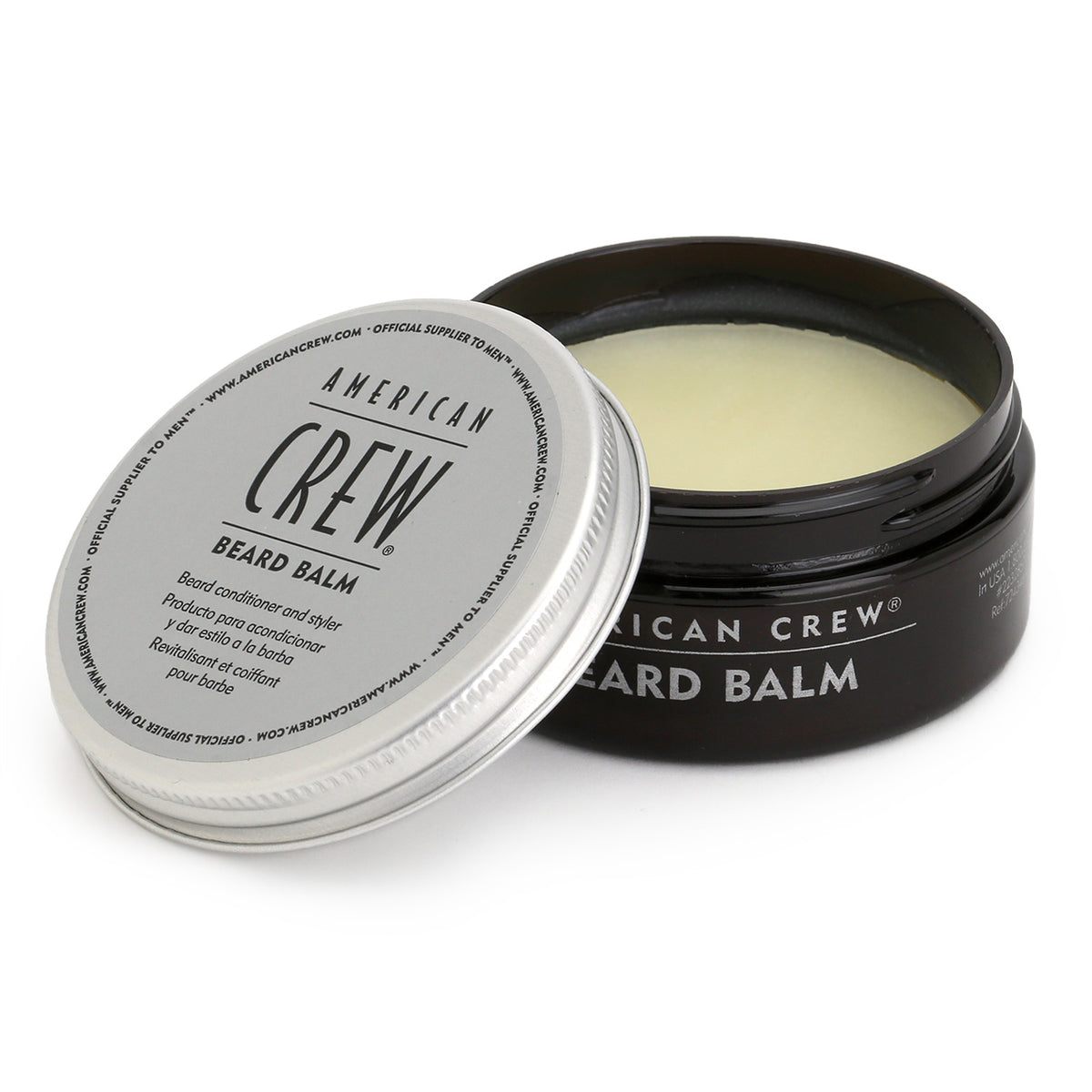 Three quarter view of the tub of American Crew Beard Balm which is black with an aluminium lid, and shows the buff-coloured product inside