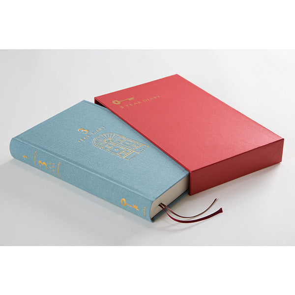 MIDORI 3 year diary has a light blue hard cover and a red slip case