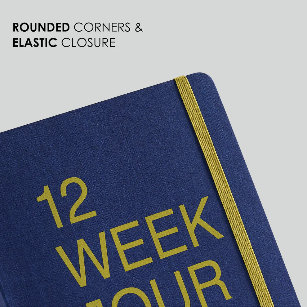 Blue notebook with '12 Week' text and elastic closure on a light gray background