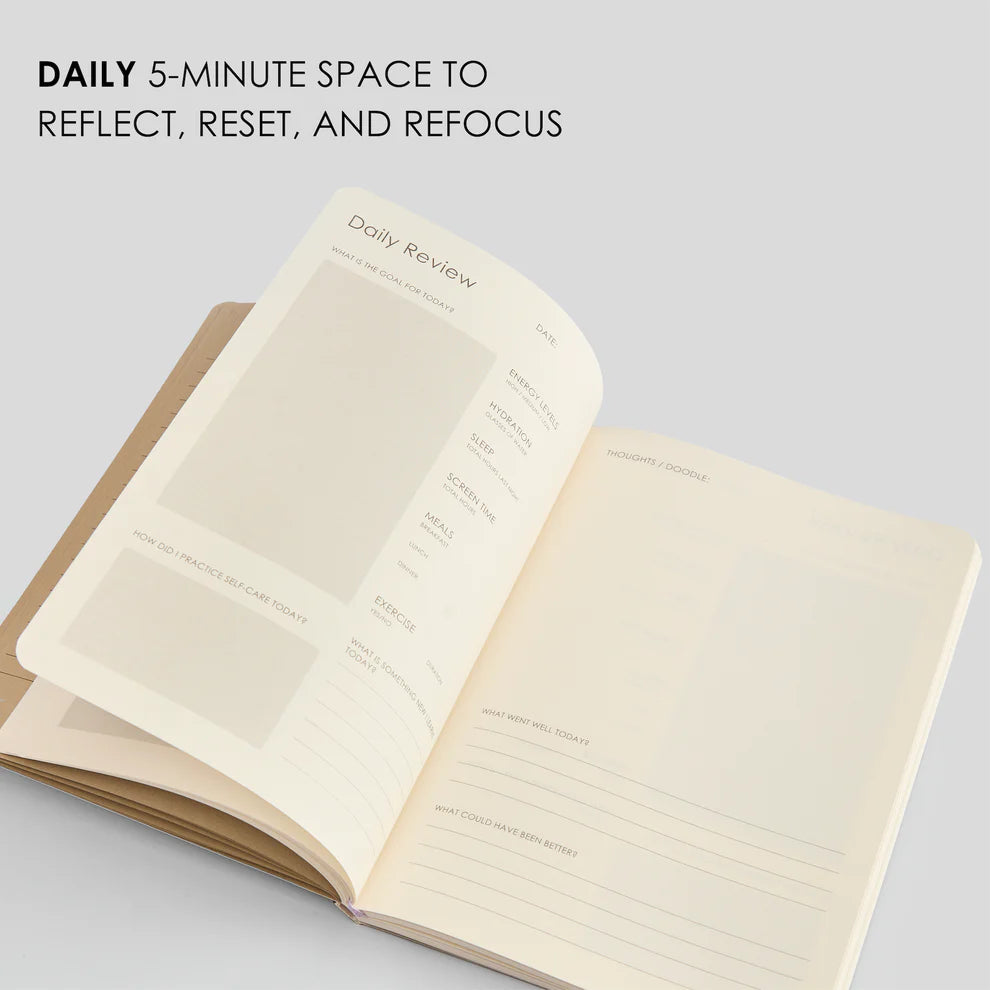 Open notebook with lined pages on a light gray background, featuring text about daily reflection.