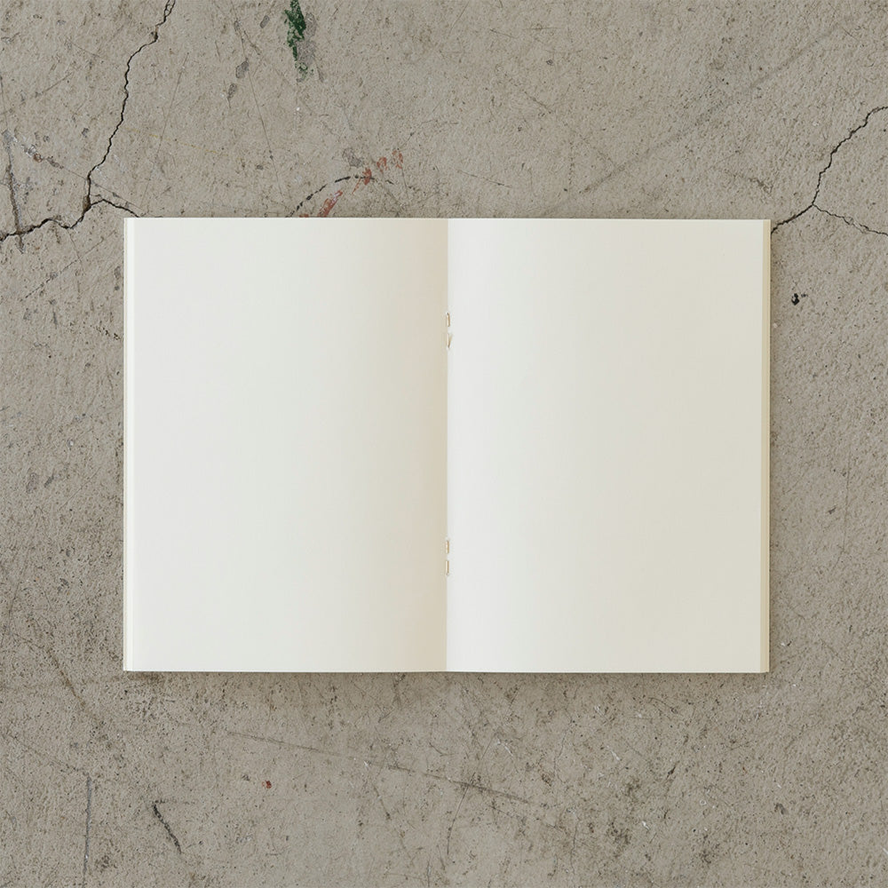 The open blank notebook on a cement slab