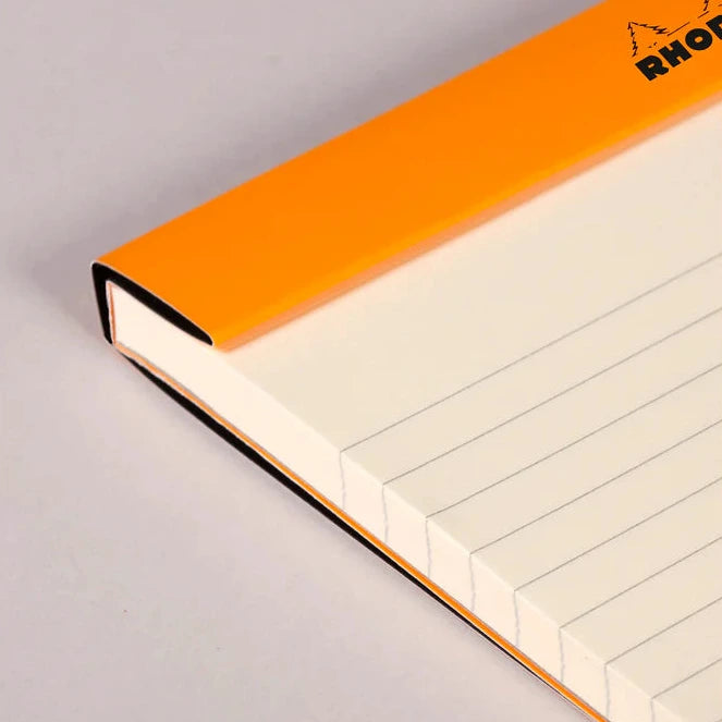 Notebook with orange binding on a gray background