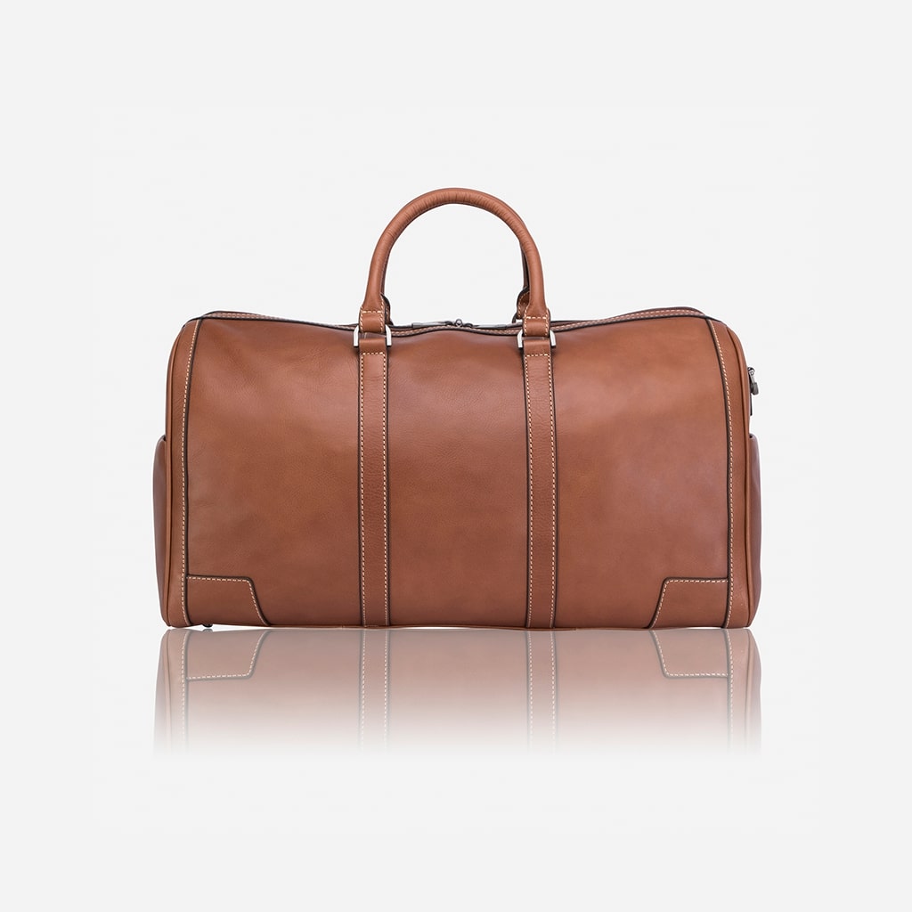 Side view showing the comfortable handles on the dark tan leather holdall