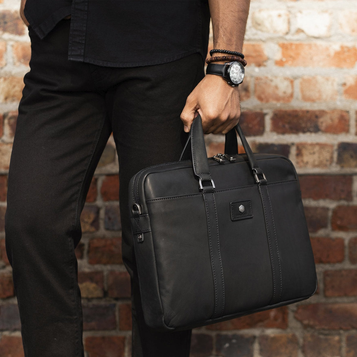 Man wearing all back holding the black leather laptop case from Jekyll &amp; Hide