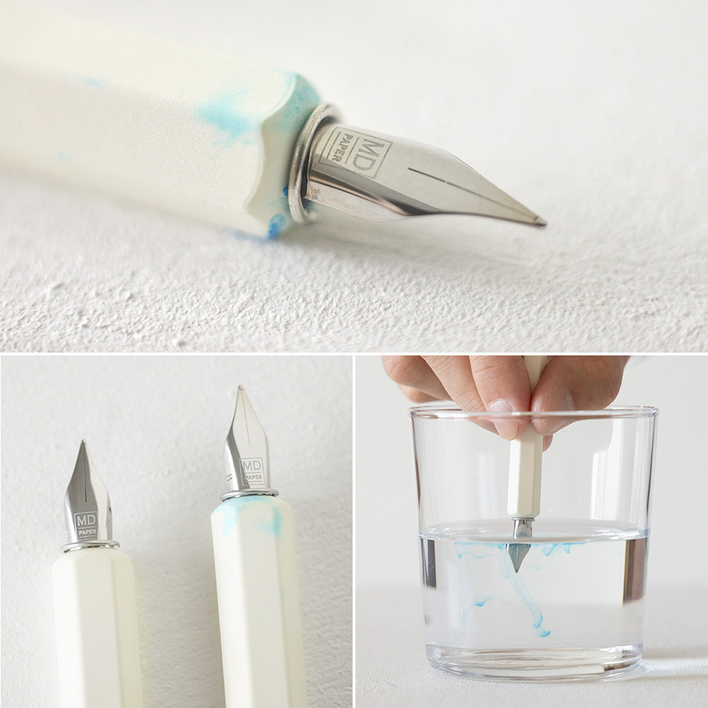 Close details of the Dip pen after use, with some blue marks on the handle, and being washed in a glass of water