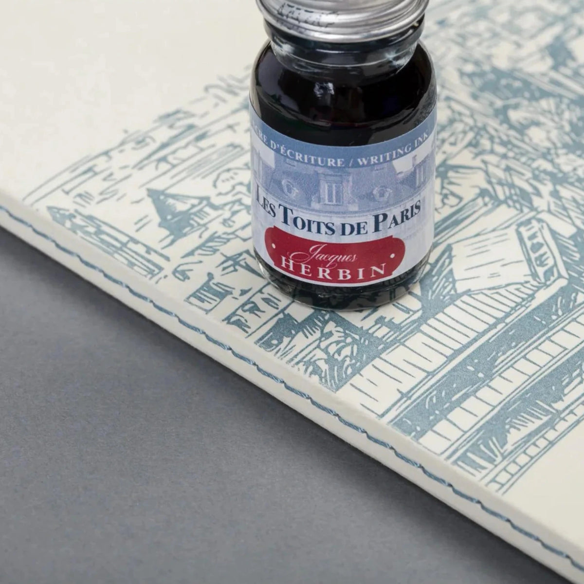 Ink bottle on a map-themed paper with 'J. Herbin' branding