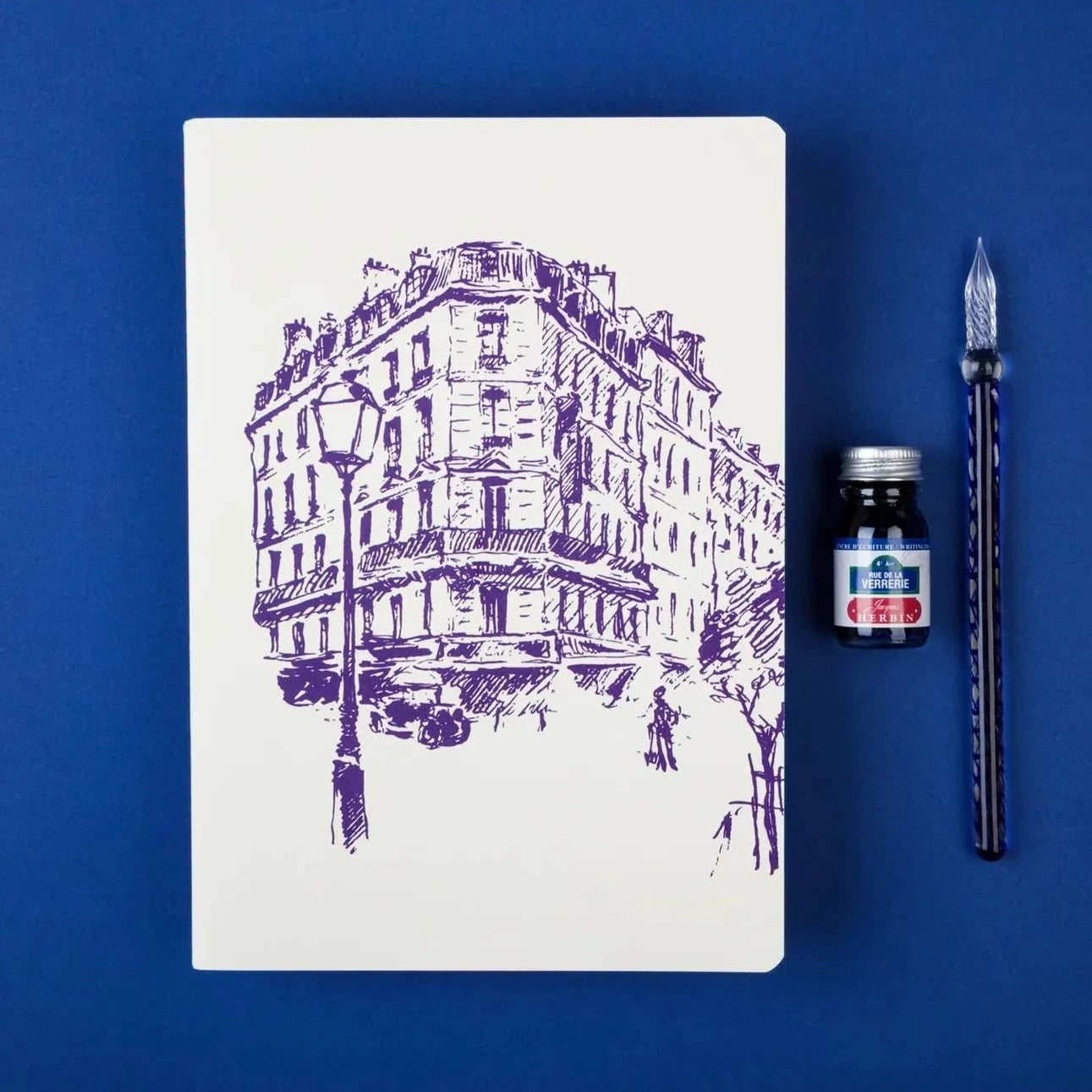 Notebook with purple street scene illustration on a white background
