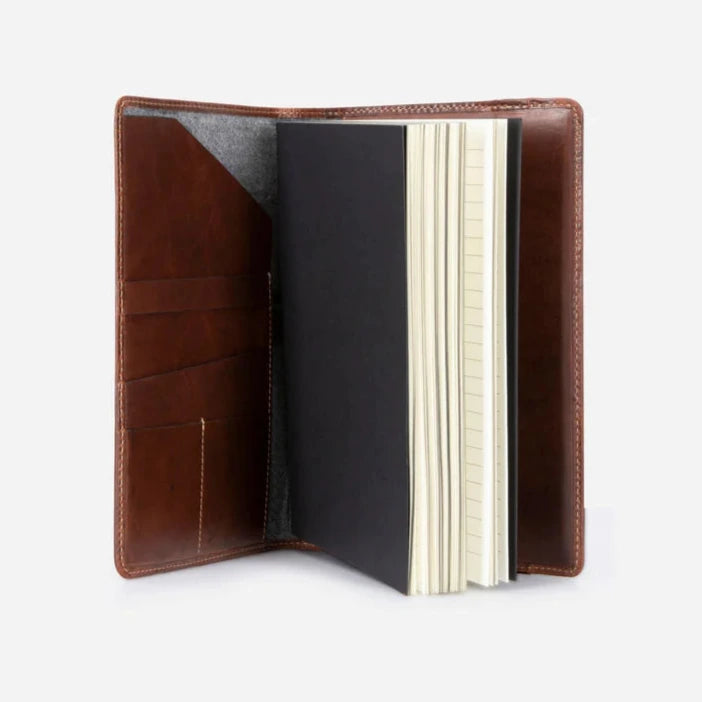 Open leather notebook showing the inner pockets with a lined notebook  on a light background