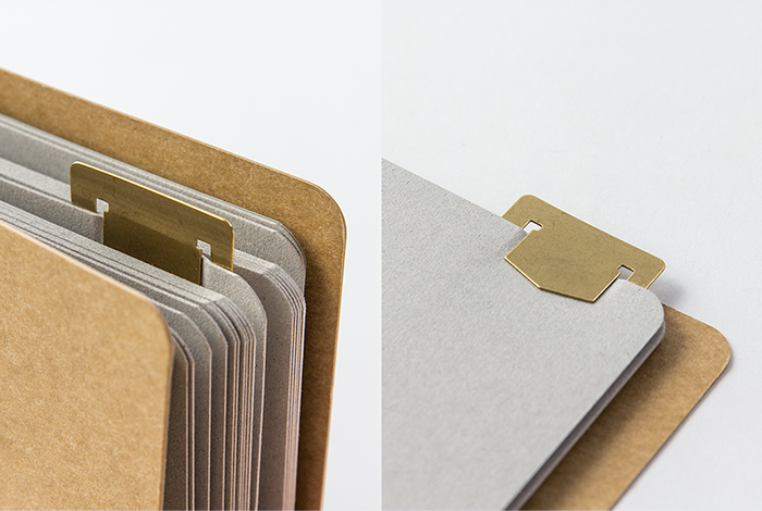 Stack of beige and gray card files with gold tabs on a light gray background