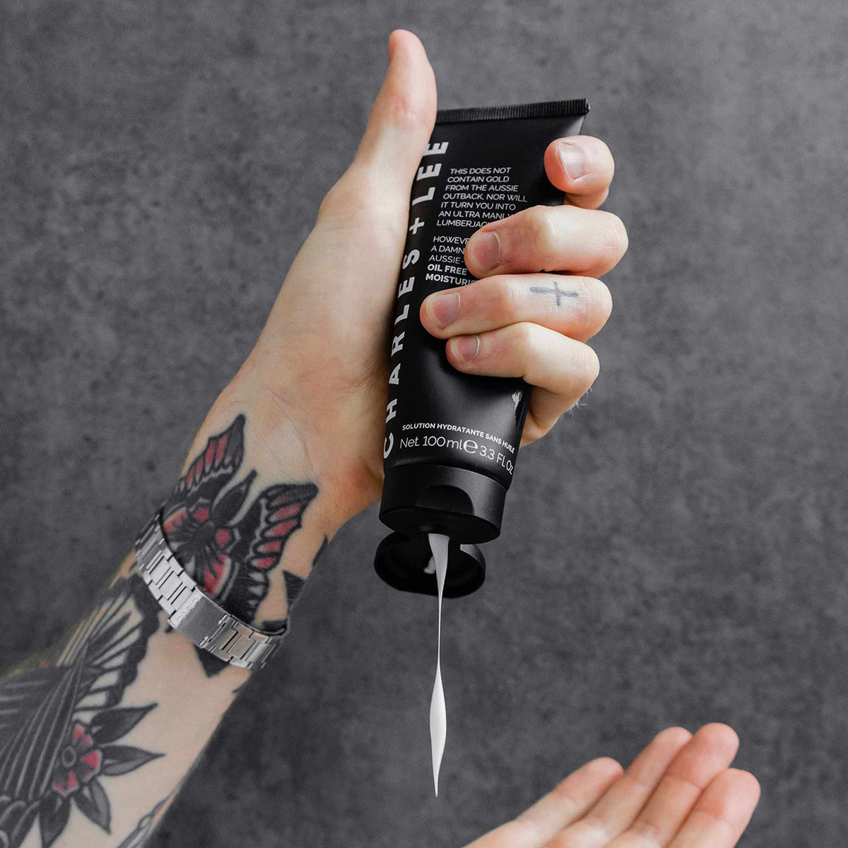 A man&#39;s hand squeezing the Oil-free moisturiser to show the viscosity