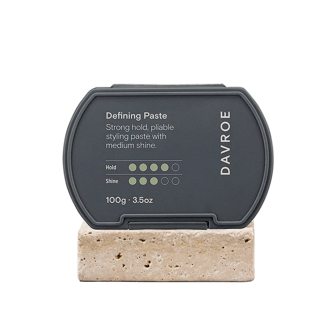 Davroe defining paste container on a stone block with a beige background