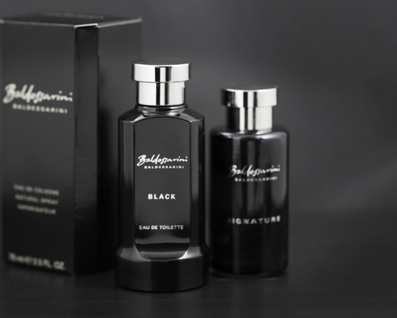 Two black Baldessarini men's cologne bottles with packaging on a dark 
