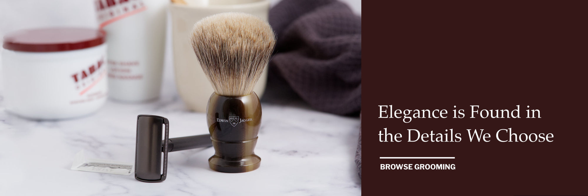 Shaving brush, Safety Razor and accessories on a marble surface with a dark waffle towel.