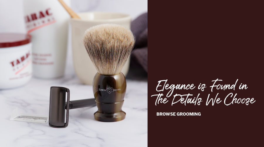 Shaving brush and DE Razor on a marble surface with a brown banner and text saying Elegance is found in the details we choose.