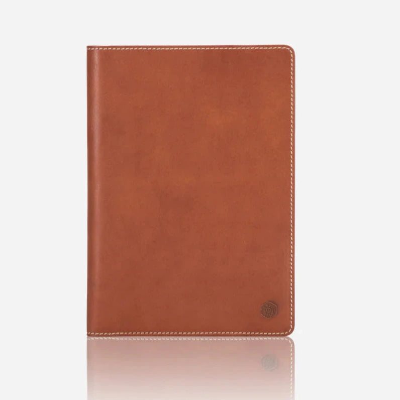Tan leather notebook with a elastic closurre on a white background