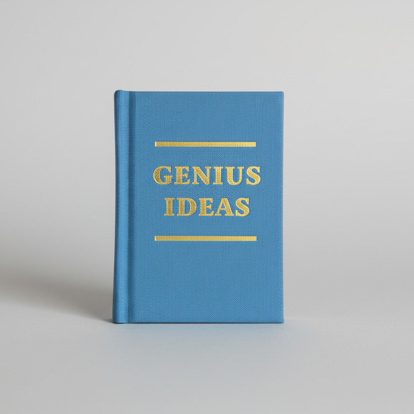 Blue notebook with 'GENIUS IDEAS' text on a gray background