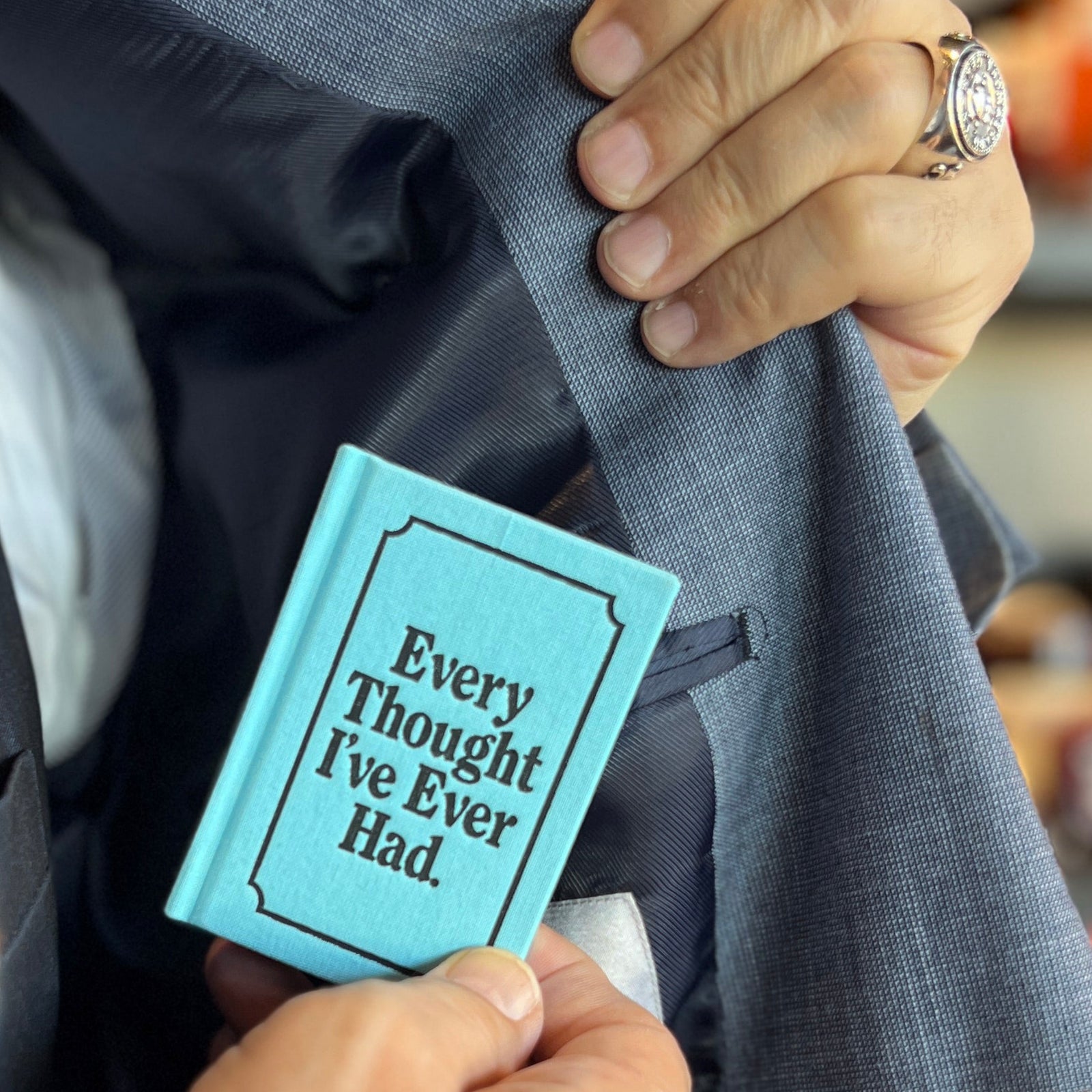 Blue notebook with 'Every Thought I've Ever Had' text on a white background