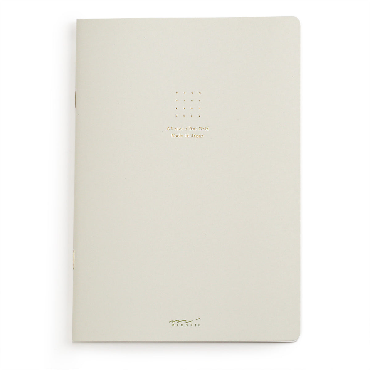 White (actually a VERY light greyish tone) dot grid A5 notebook from midori with gold coloured foil stamping on the cover and gold coloured staples
