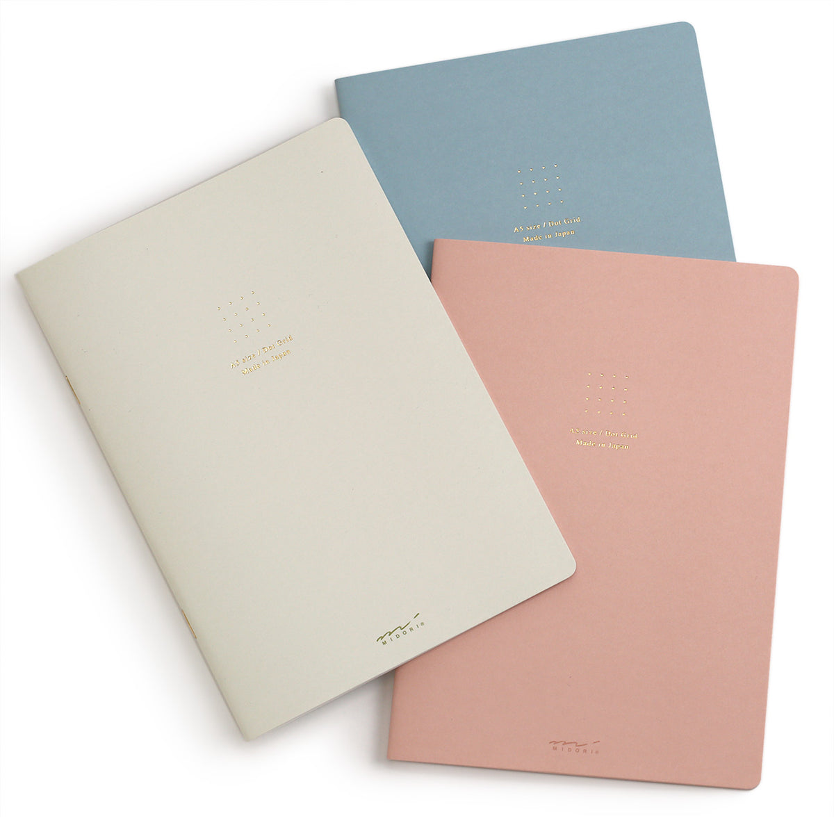 overlapping notebooks from a topview showing the pink blue and white covers with gold stamping