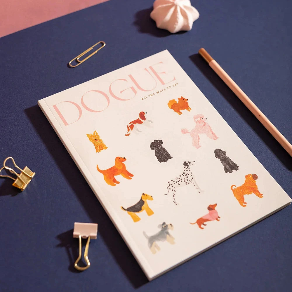 Notebook with dog illustrations on a blue surface with office supplies.