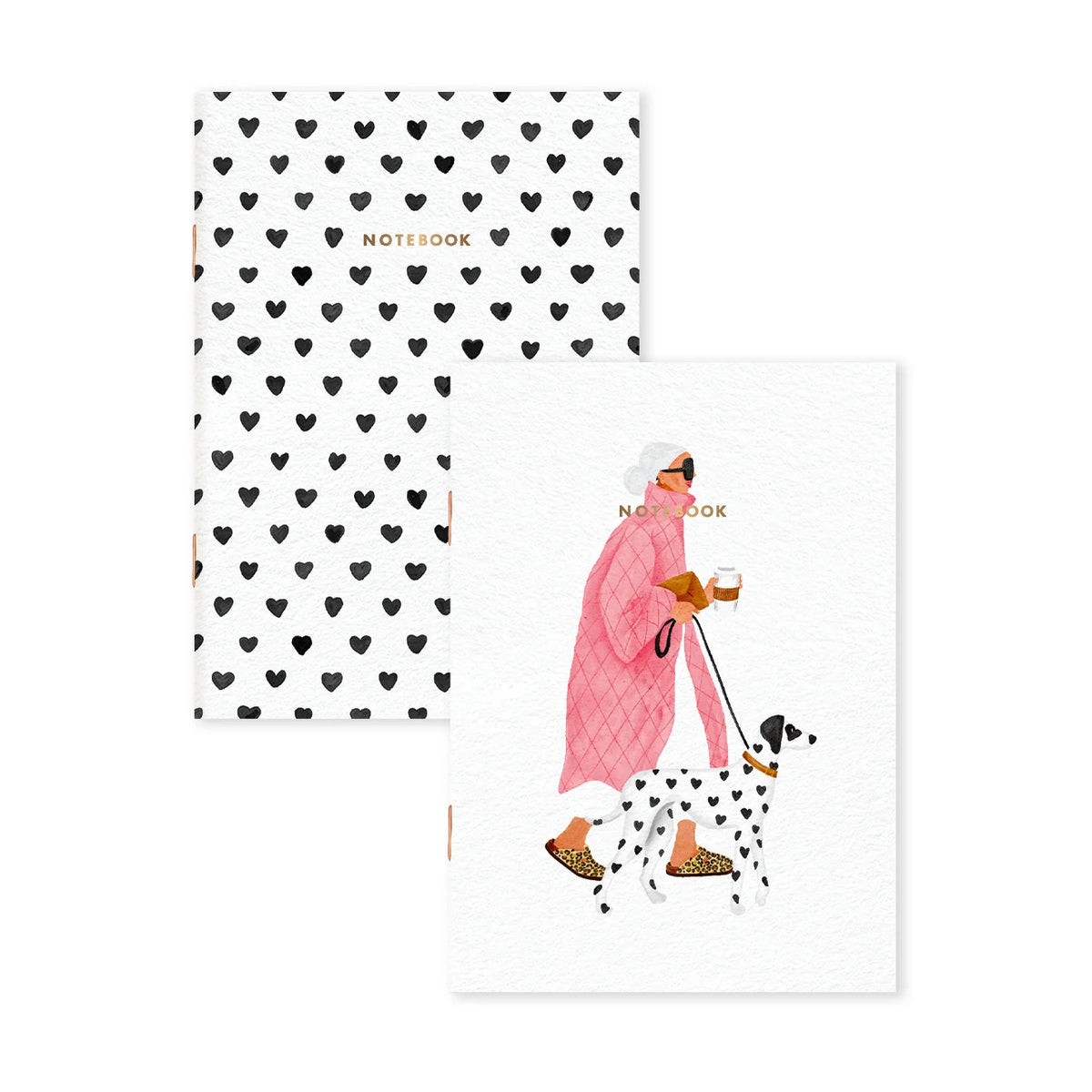Two notebooks on a white background. The back cover of one notebook features a repeating pattern of small black hearts, and the front cover shows an illustration of a woman in a pink coat walking a Dalmatian while holding a coffee cup.
