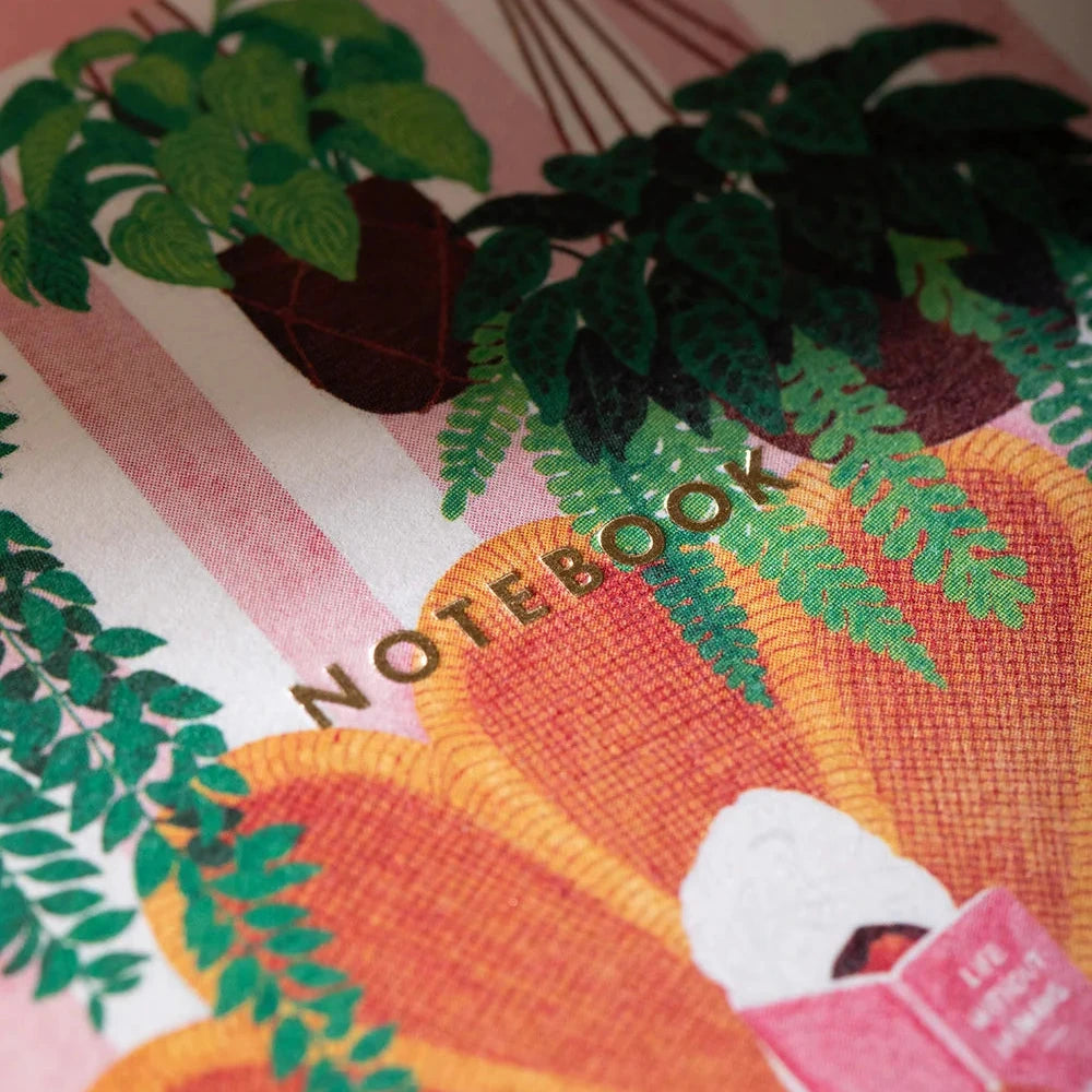 Notebook with plant illustrations and a person reading a book on a striped background