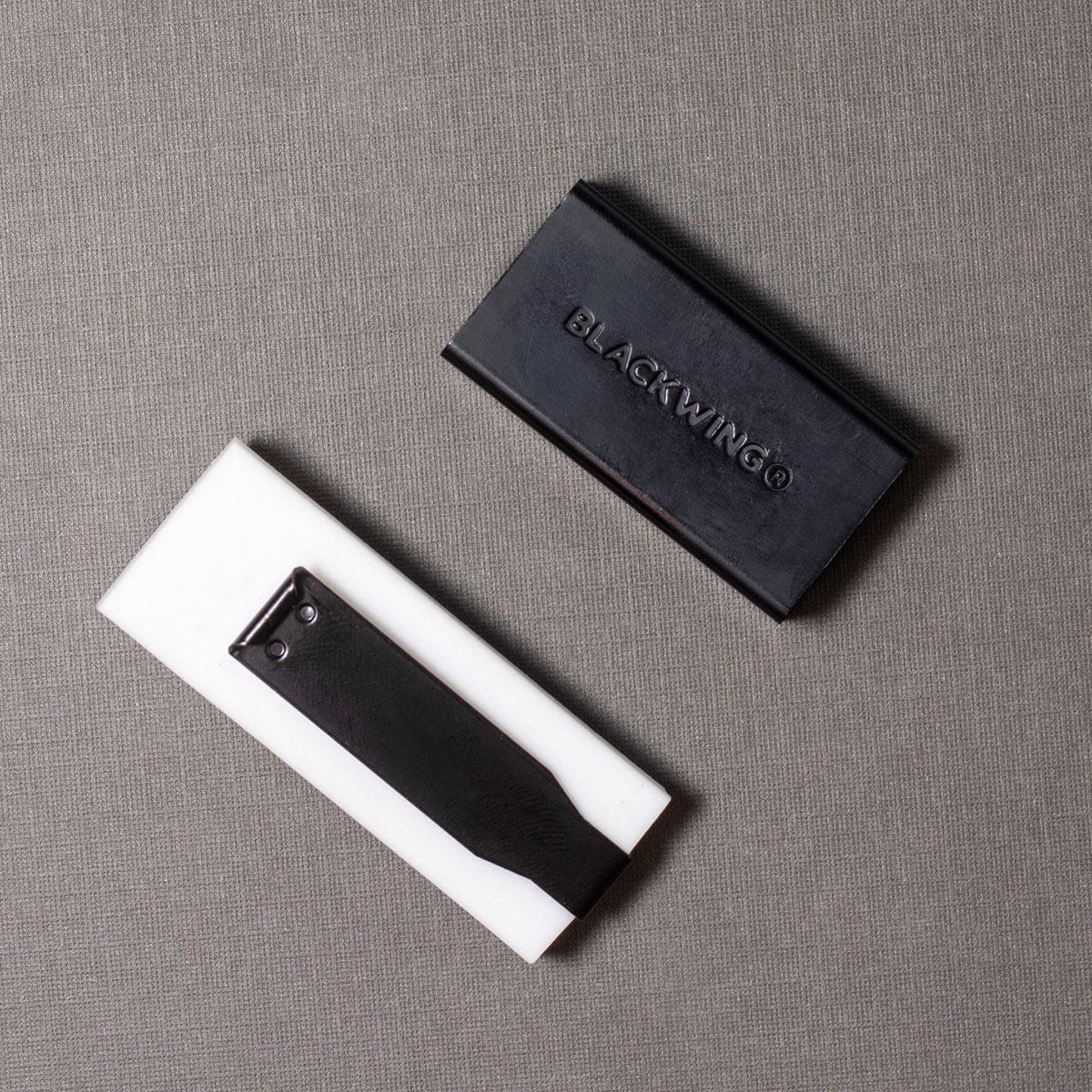 Two black and white items with 'BLACKWING' branding on a gray surface