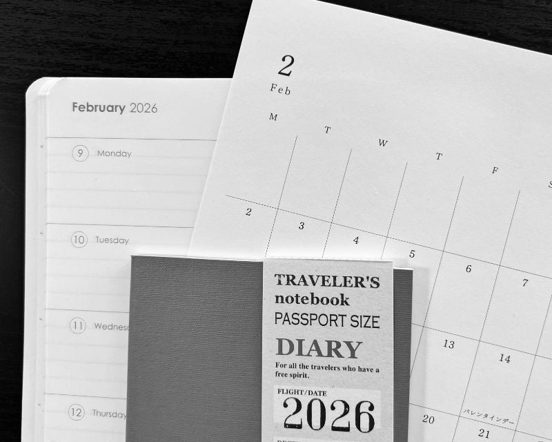 Calendar pages showing February 2026 with a travel notebook labeled 'Passport Size Diary' for 2026.