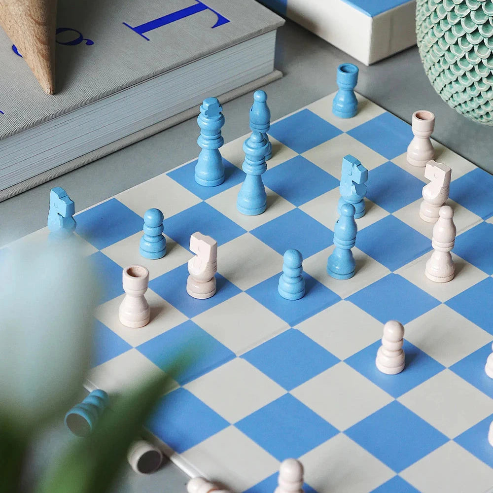 Chessboard with blue and white pieces on a checkered surface