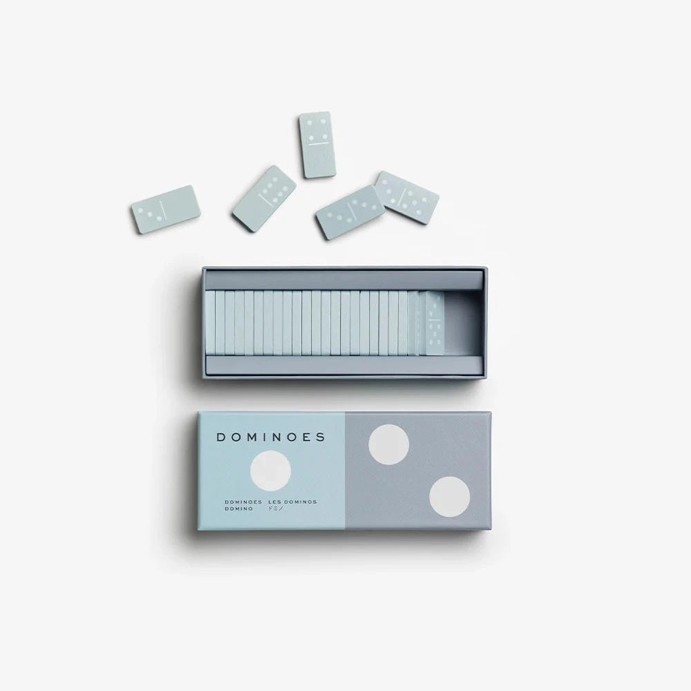 Box of dominoes with white dots on a light gray background