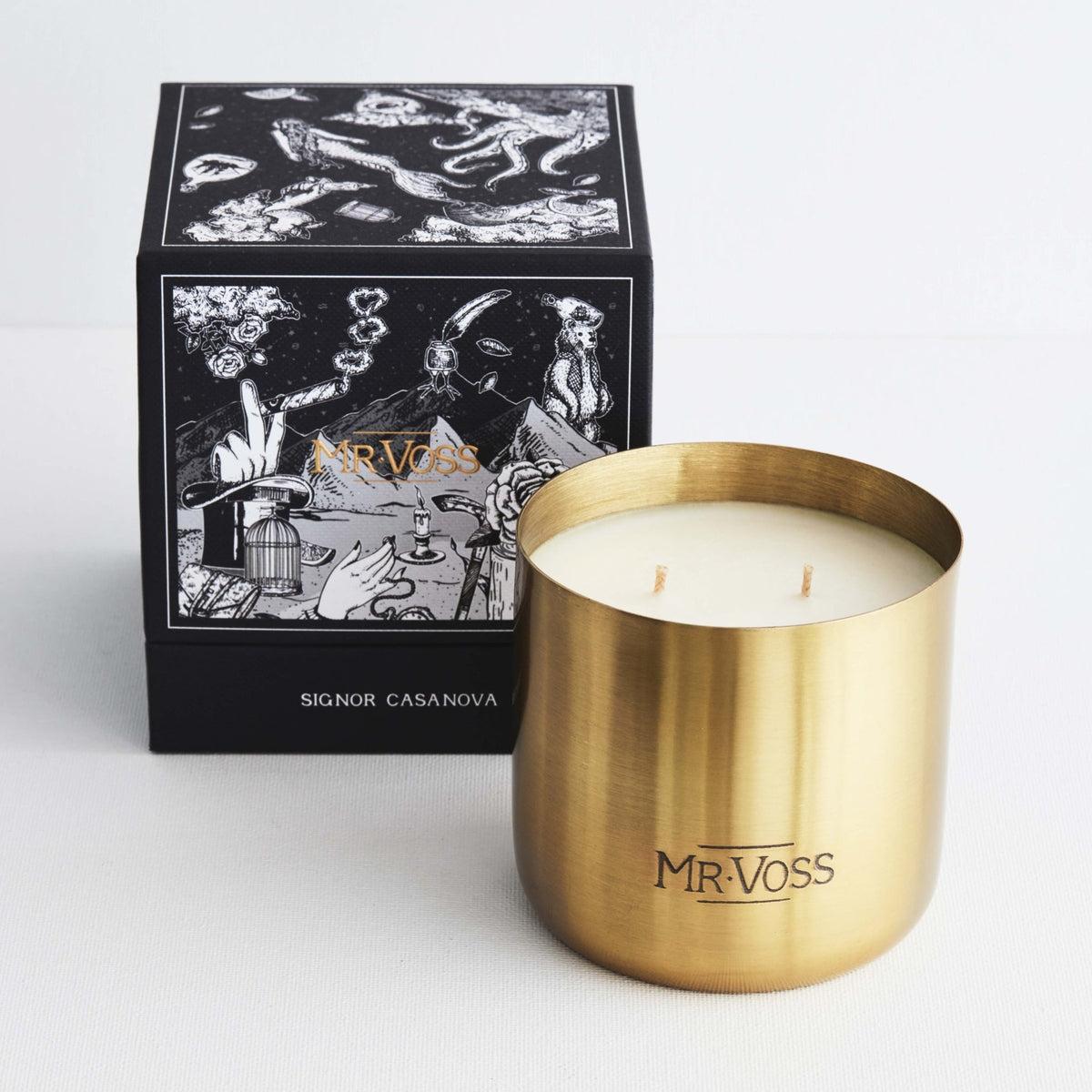 Gold candle holder with 'MR. VOSS' branding next to a black decorative box on a white background
