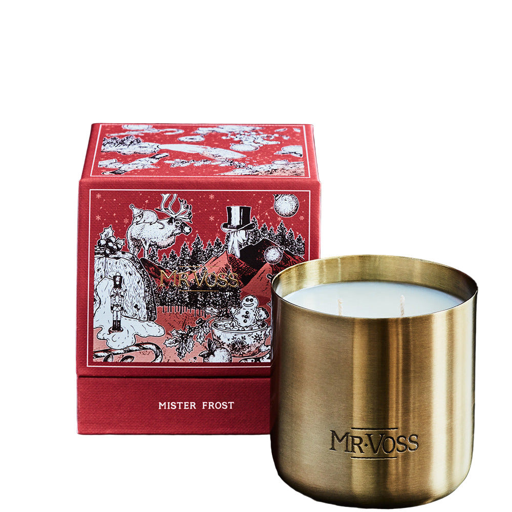 Gold candle with 'MRVOSS' branding next to a red decorative box on a black background