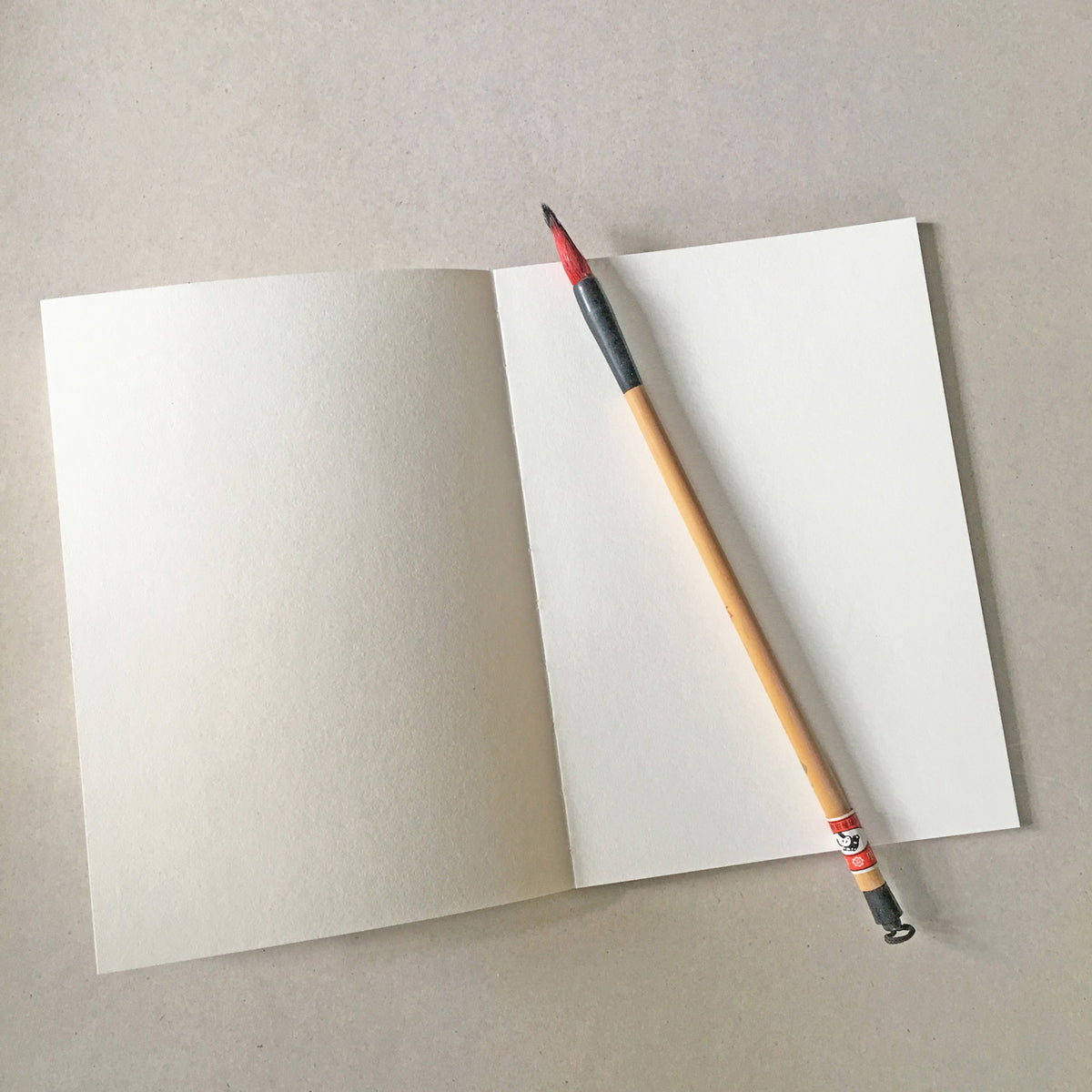 Open notebook with a pencil on a gray background
