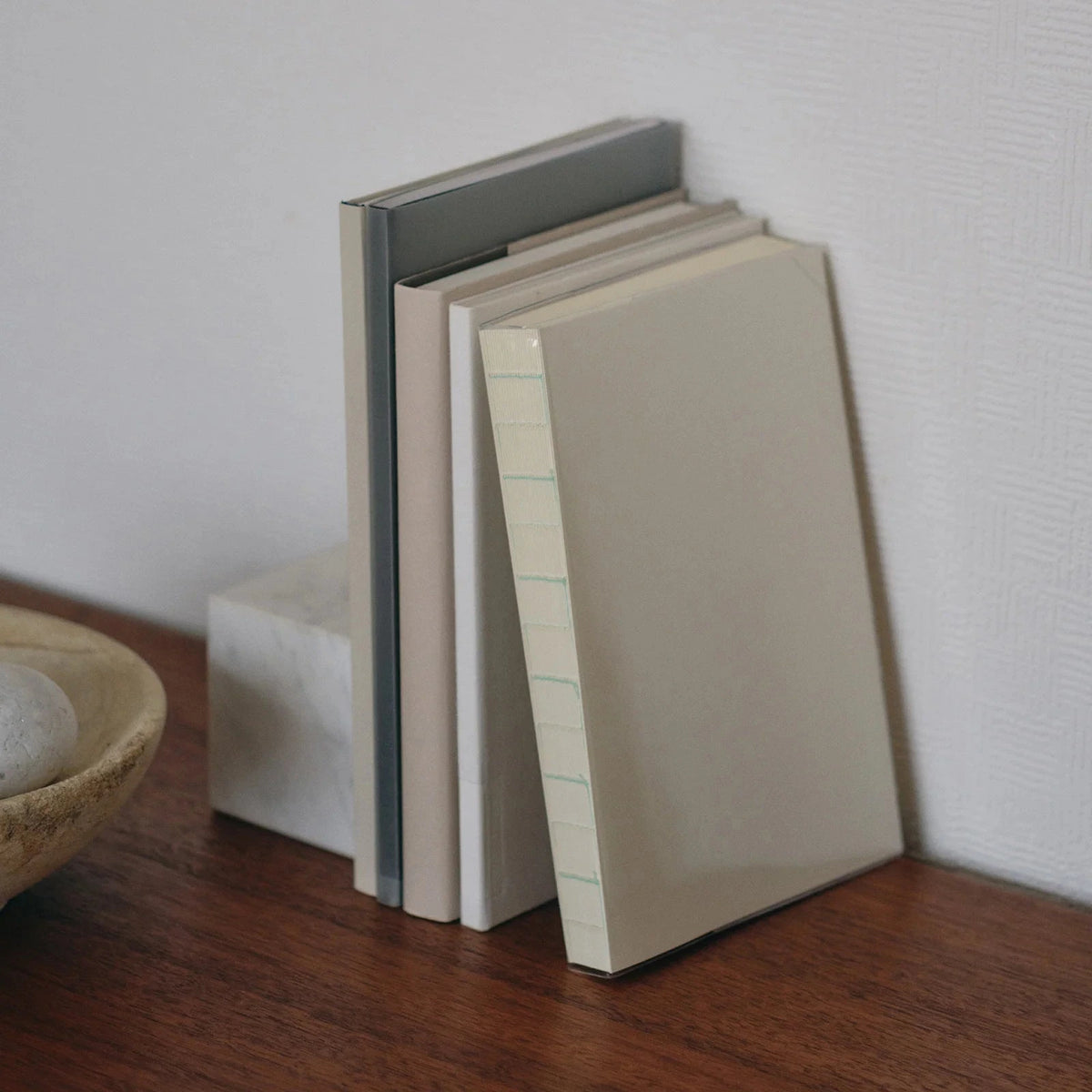 Stack of notebooks on a wooden surface with a neutral background