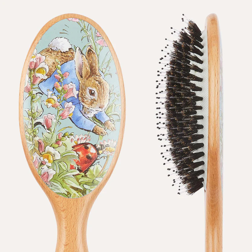 Wooden hairbrush with a decorative handle featuring a cartoon rabbit and floral design.