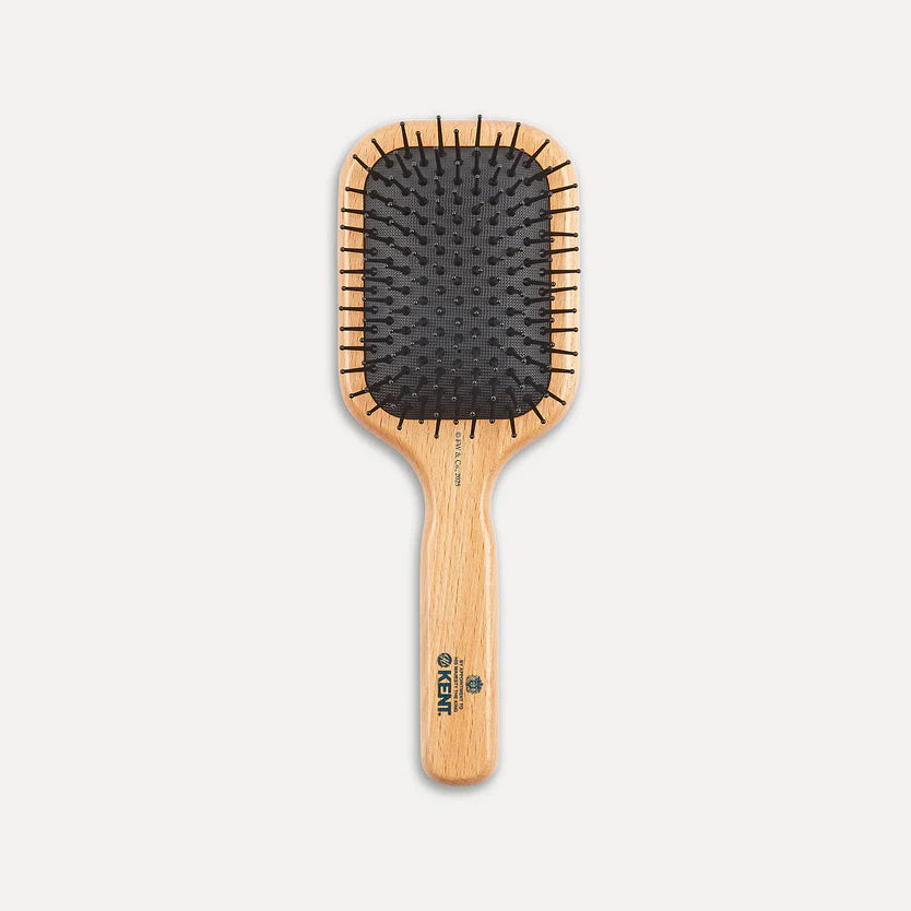 A paddle hairbrush with a light natural wood handle and frame, black bristles, and a visible KIKI logo printed on the handle, shown against a plain light gray background.