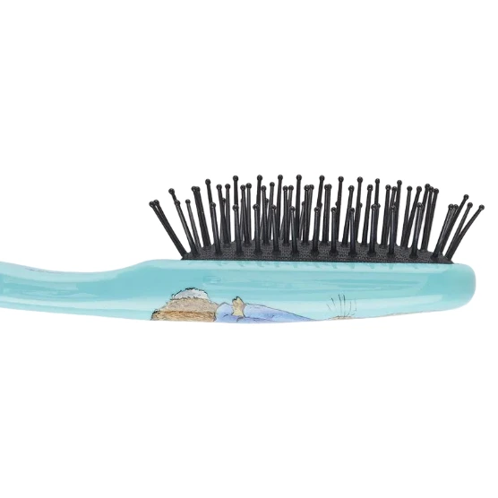 A close-up side view of a hairbrush with a glossy light blue handle, black bristles, and a printed illustration of a beach scene on the handle.