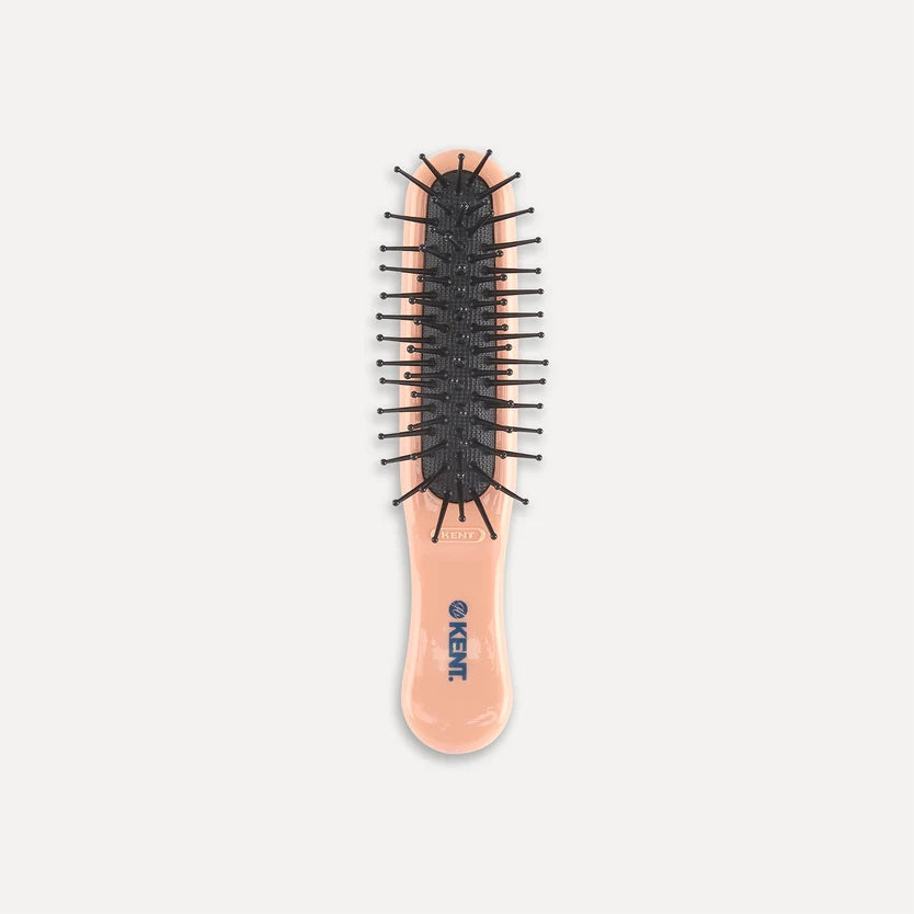 A peach-colored hairbrush featuring a detailed illustration of Peter Rabbit on the handle, with black bristles and the text 'Peter Rabbit' printed near the bottom.