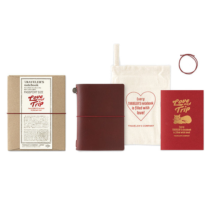 TRAVELER'S notebook passport size with a limited edition Love and Trip design, featuring a vibrant red leather cover with debossed detailing. The product also includes a cardboard packaging, a muslin slip bag, and a limited edition refill booklet with gold foil design.