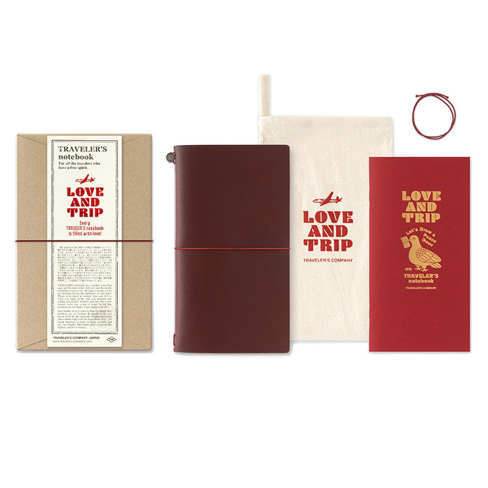 TRAVELER'S notebook with a limited edition Love and Trip design, featuring a vibrant red leather cover with debossed detailing. The product also includes a cardboard packaging, a muslin slip bag, and a limited edition refill booklet with gold foil design.