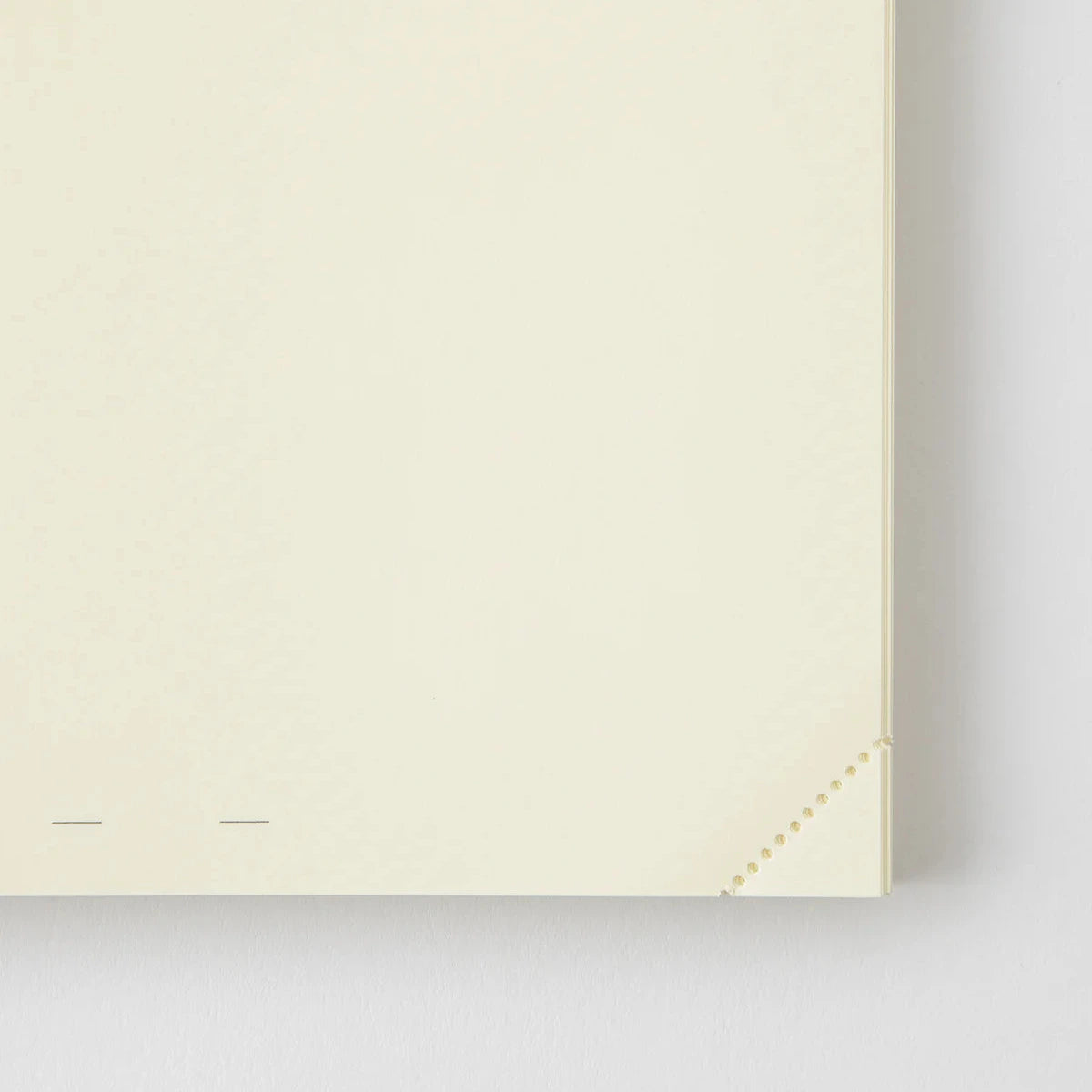 Beige notebook with a gold corner on a light gray background
