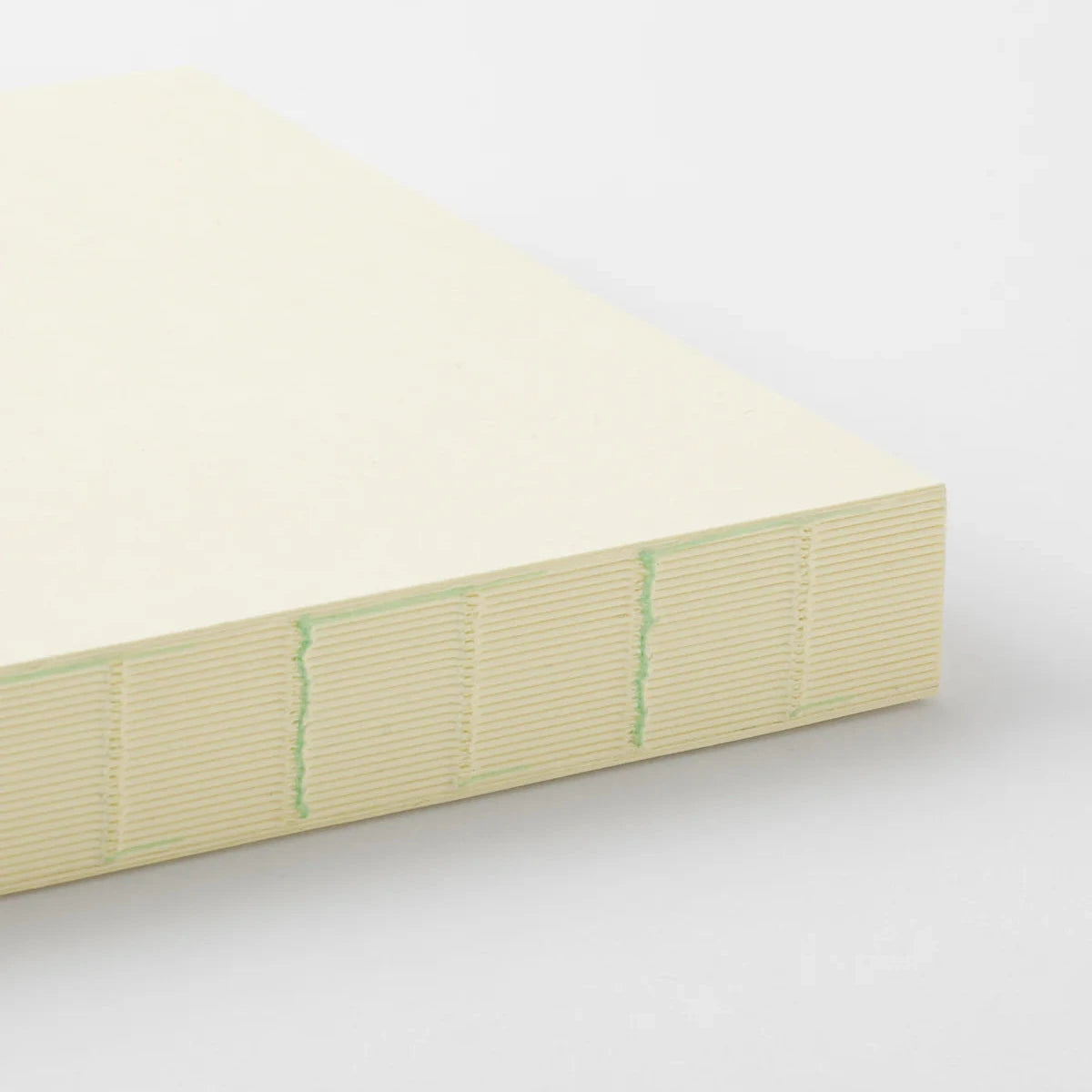 Rectangular block of light-colored material with green lines on a white background