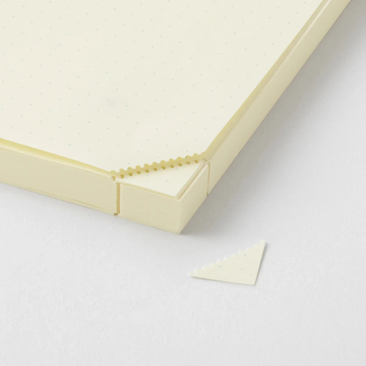 Close-up of a beige rectangular object with a textured surface on a light gray background