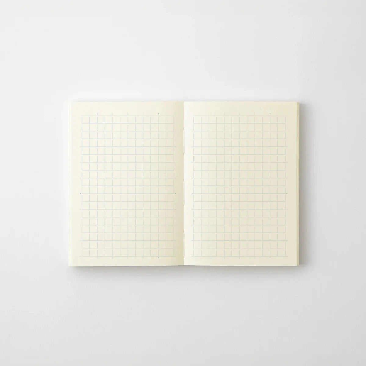 Open notebook with grid pages on a light gray background