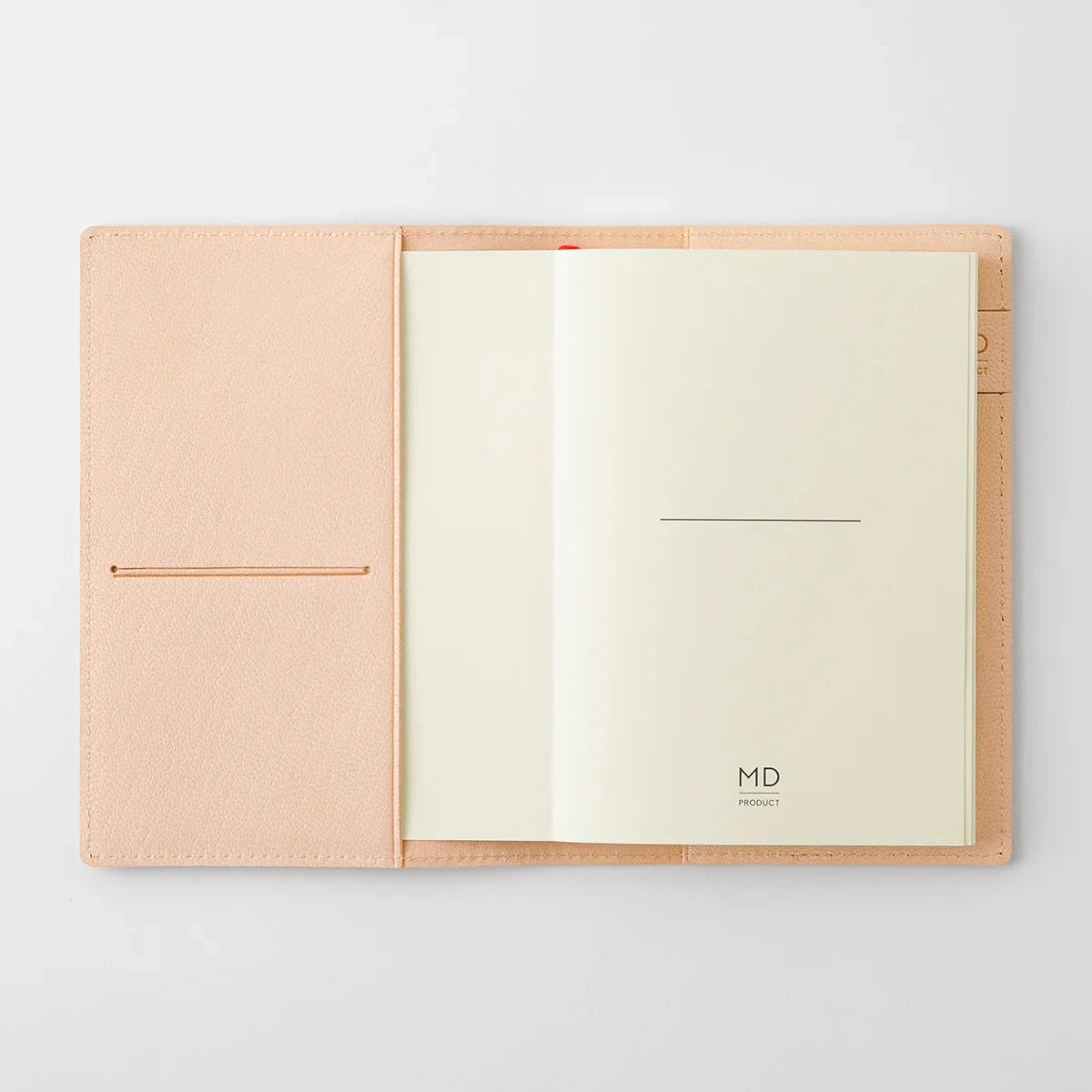 Open notebook with beige cover and cream pages on a light gray background