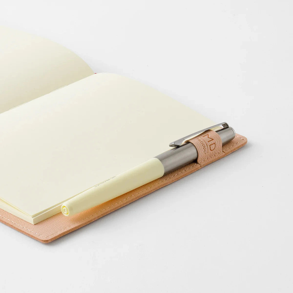 Pen with wooden clip on a notebook on a white background