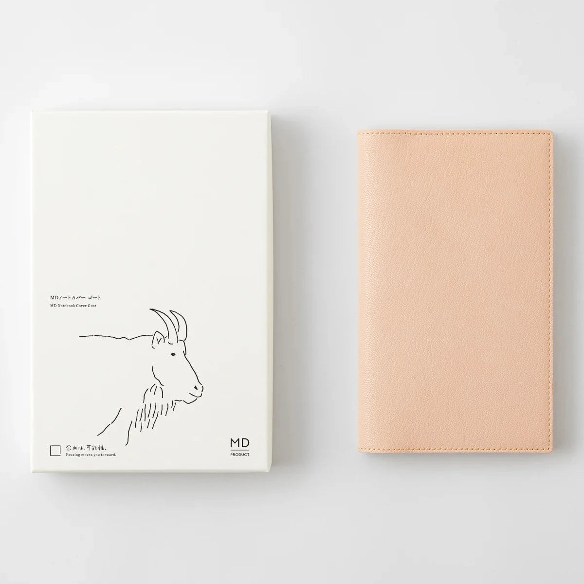 Beige notebook and white box with goat illustration on a light gray background