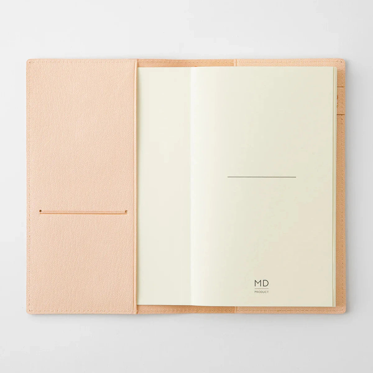 Open notebook with beige cover and cream pages on a light gray background