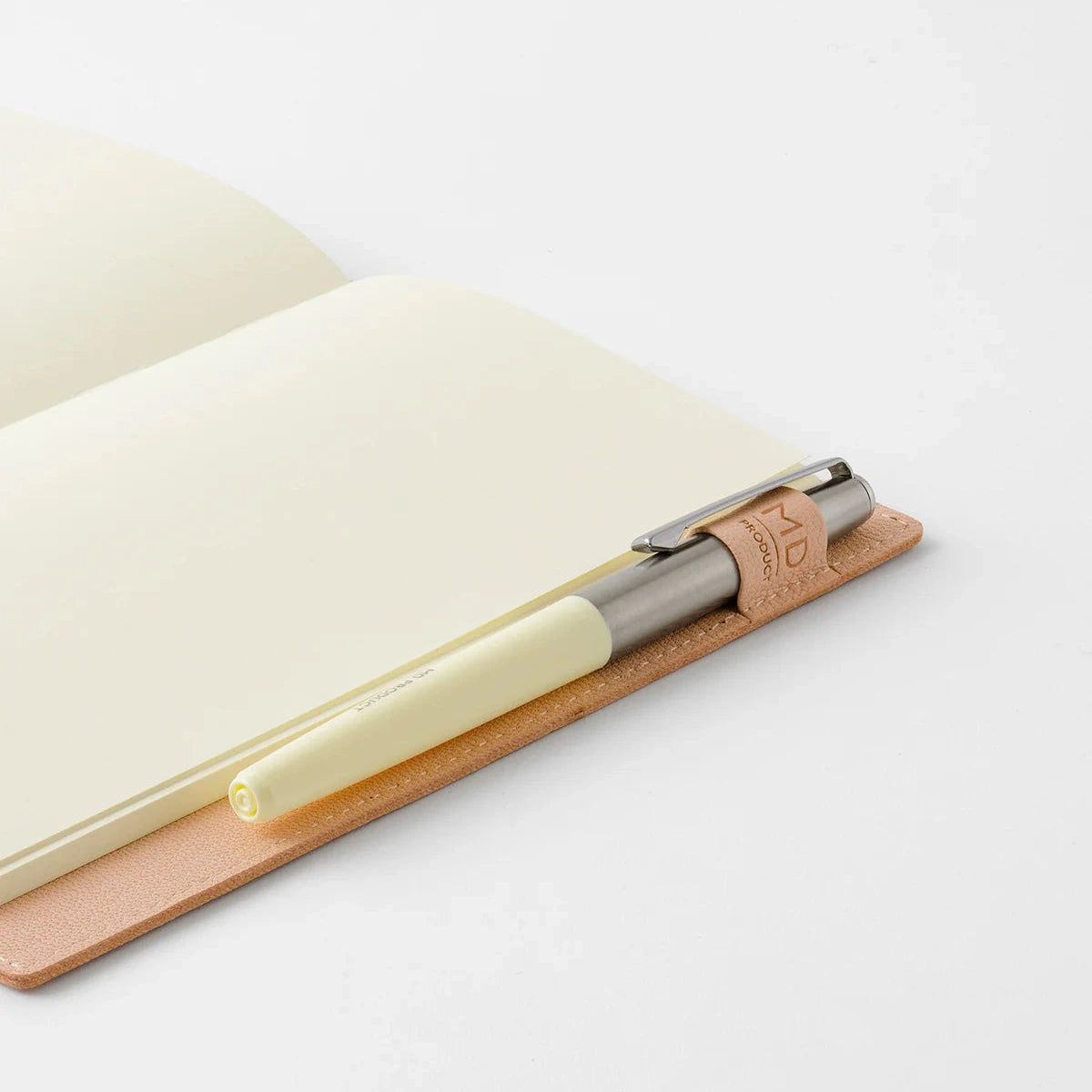 Pen with cork cap and beige body on a white surface